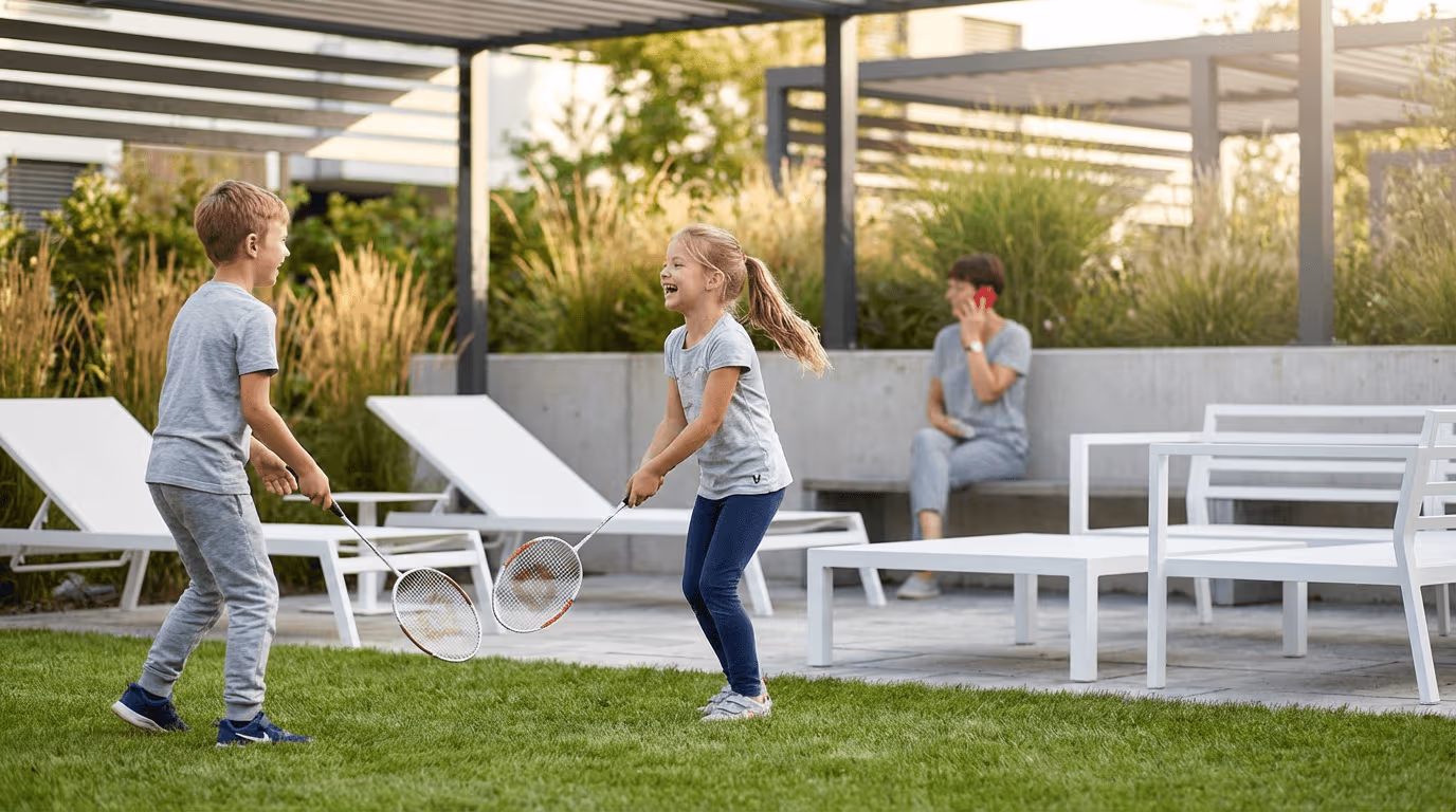 Zwei Kinder spielen im Garten Federball